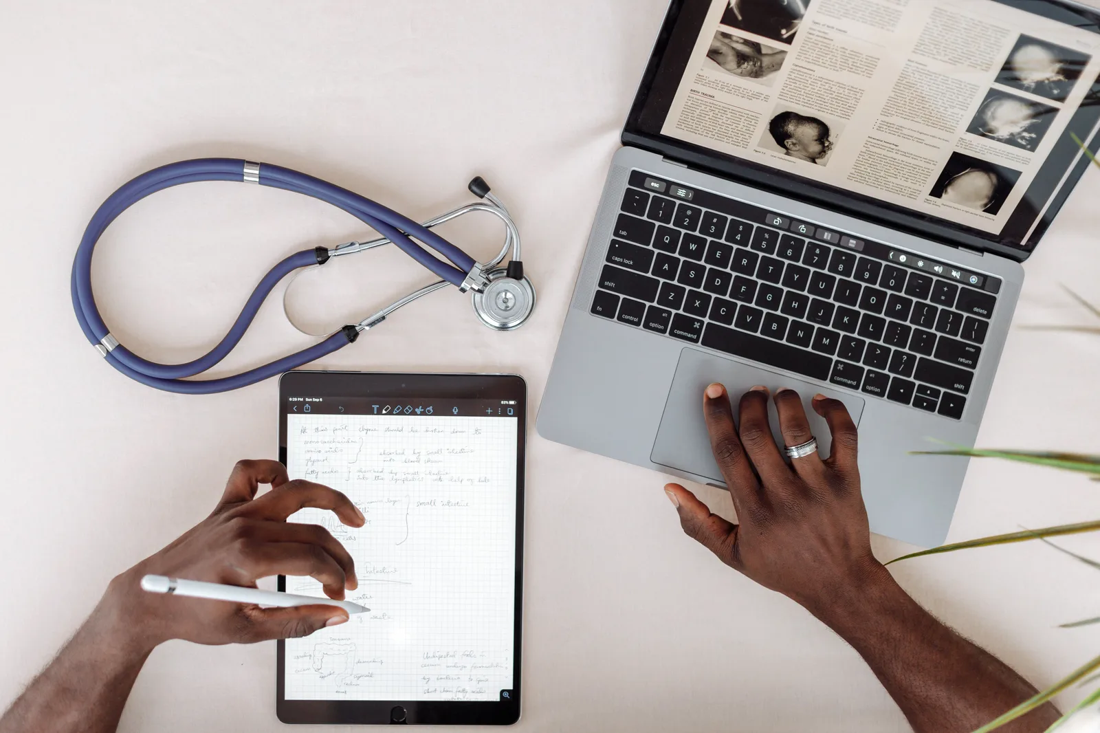 Healthcare professional using tablet and laptop for research with stethoscope on desk. Healthcare Content Marketing Best Practices