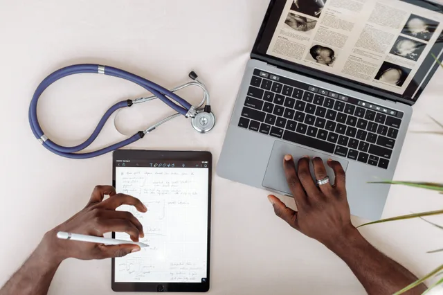 Healthcare professional using tablet and laptop for research with stethoscope on desk. Healthcare Content Marketing Best Practices