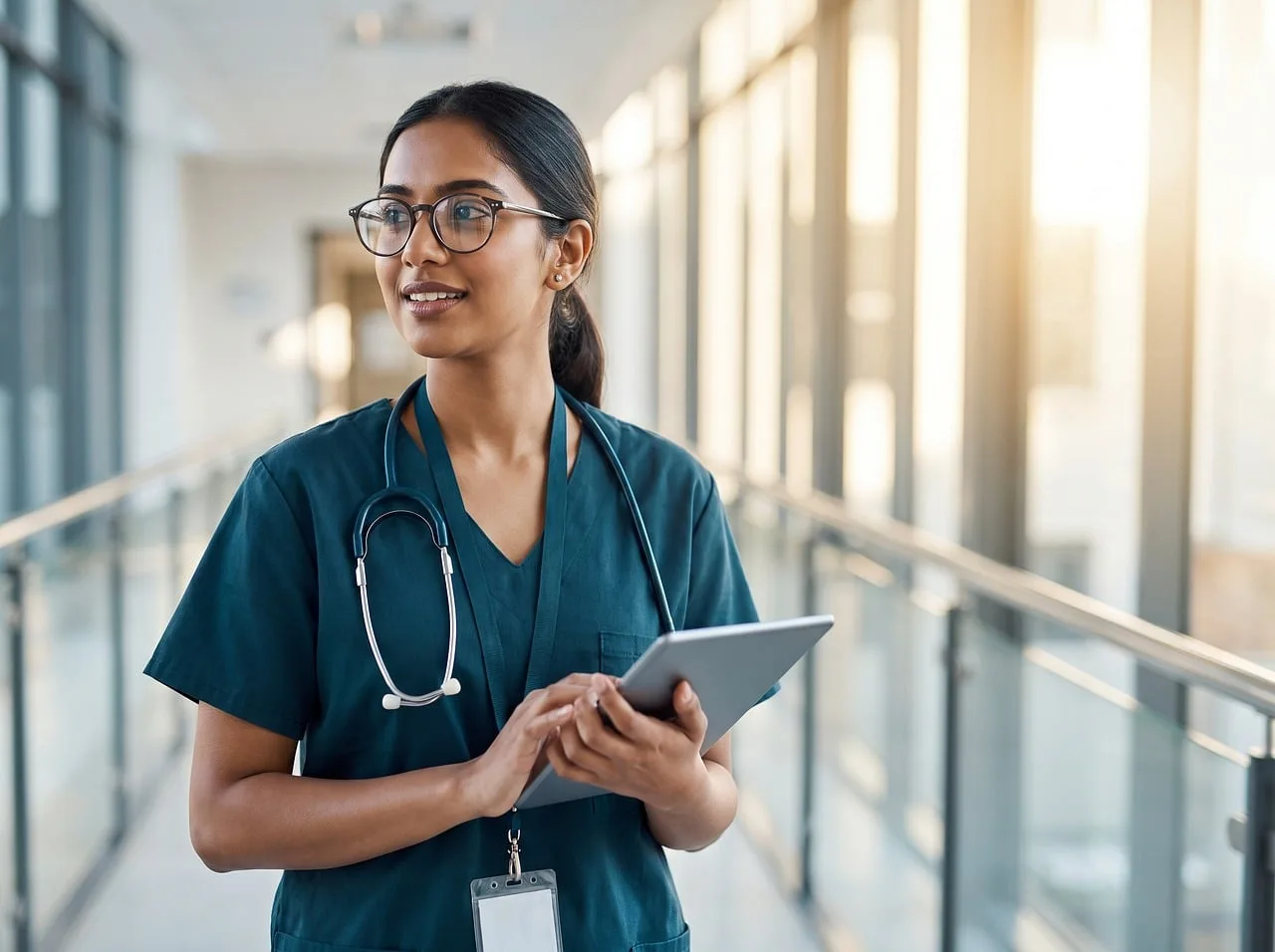 doctor, tablet, stethoscope, hospital, nurse, healthcare, clinic, scrubs, woman, glasses, professional, technology, smiling, confident, healthcare worker, modern, light, interior. HIPAA Compliant Call Tracking: Four Checks for Clinics